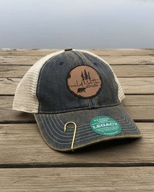 Trucker hat with leather patch on a wooden dock by a lake